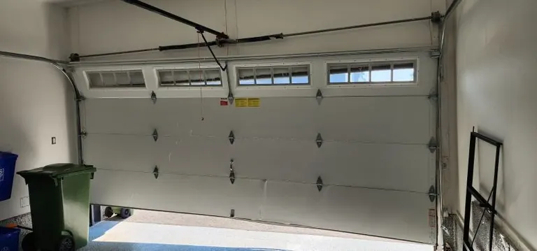 Garage door hanging unevenly inside a residential garage