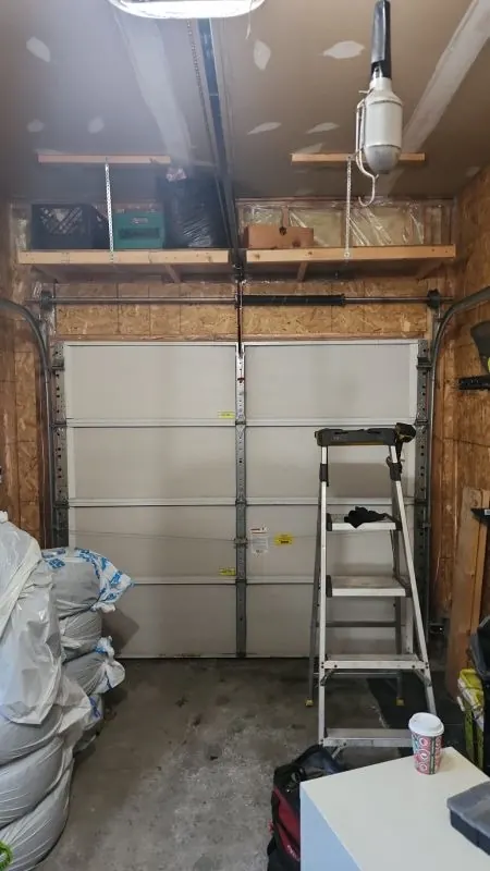 Garage door, spring system, and ladder inside a residential garage
